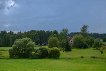 a beautiful green meadow with dark gray dedes before the rain
