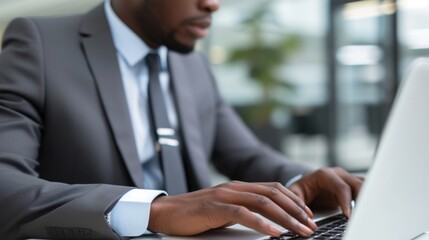 Fototapeta premium A businessman in a suit typing on a laptop