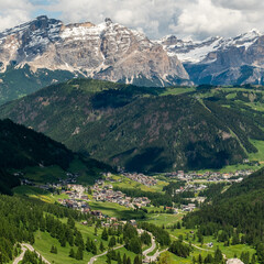 Colfosco Against Majestic Peaks: A Scenic View from the Sella Group Hiking Trail