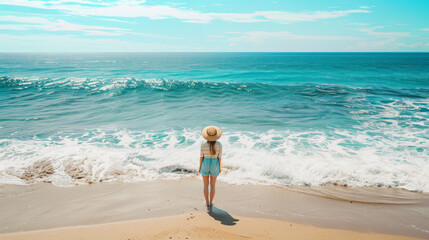 A woman in a straw hat standing on a sandy shore, gazing at the vast, tranquil ocean under a bright, sunny sky.