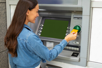 Woman using ATM machine for money withdrawal, putting credit card, withdrawing her cash from card...