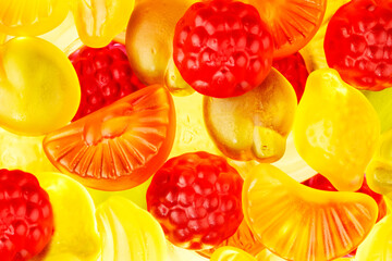 closeup fruit gums jelly candies with red strawberries, green apples, yellow bananas and orange