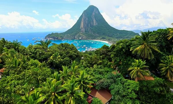 Downtown Soufriere, Saint Lucia with famous Petit Piton mountain in background. Aerial reveal of colorful town and tourist attracting landscape 4k video