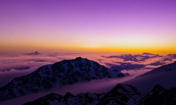Colorful golden sunset in snowy mountains in winter above mist clouds. Dolly shot time lapse day to night. 4K video Dynamic motion, dynamic blur, 30x speed, unsharp edges.