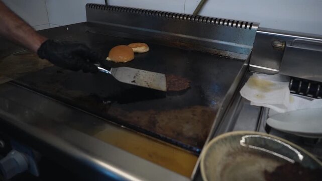  chef flips delicious juicy patties on grill with spatula for smashed burger