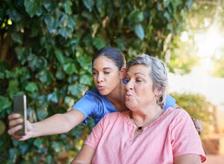 Naklejka premium Assisted living, pout and selfie of nurse with old woman outdoor at retirement home for social media. Healthcare, medical or memory with caregiver and senior patient kissing for photograph in garden