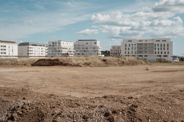 Fototapeta premium un terrain vide devant devant des nouveaux immeubles neufs , dans un quartier naissant