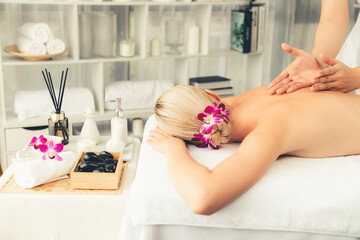 Obraz na płótnie Canvas Caucasian woman customer enjoying relaxing anti-stress spa massage and pampering with beauty skin recreation leisure in day light ambient salon spa at luxury resort or hotel. Quiescent