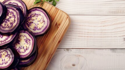 Fototapeta premium Eggplant slices on wooden board white table space for text