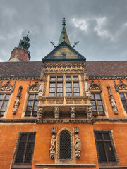Detailed view of an ornate historical building facade featuring intricate carvings and sculptures, highlighting the rich architectural heritage in Wroclaw, Poland.