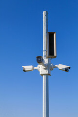 Security video cameras on a pole on blue sky background