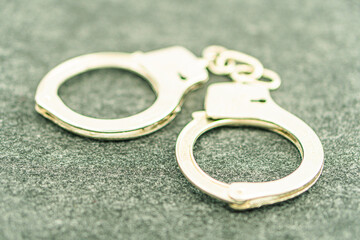 Handcuffs on an empty background, photography. Police handcuffs on dark background with copy space....