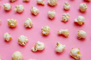 Sweet popcorn on pink background.