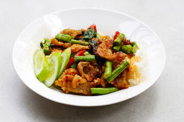 Rice topped with stir fried pork and red curry paste with yard-long bean