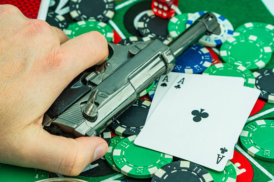 Handcuffs and a gun on a poker table - casino crime concept, underground casinos. illegal games, gambling concept. set of playing cards with dices, money and chips, on table. Casino concept, games.