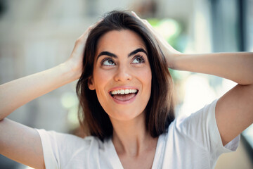 Portrait of smiling young woman posing while looking at camera in the living room at home.