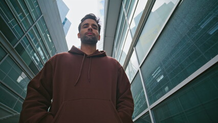 City explorer looking camera at contemporary buildings. Closeup urban man walk