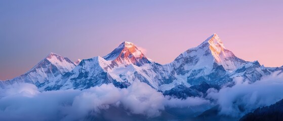 Obraz premium A mesmerizing image of snowcapped peaks at sunrise with a soft glow illuminating the snowy summits
