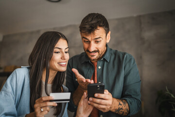 Adult caucasian couple buy online on mobile phone with credit card