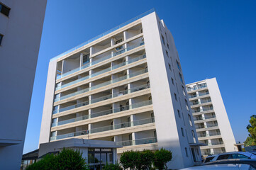 The facade of a modern residential multi-storey building, viewed from below