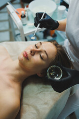 Fototapeta premium A woman with a mask on her face. Facial skin care. A woman's face with an organic mask to moisturize the skin.