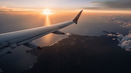 Naklejka premium An airplane wing view during flight with the land and sea below, beautifully lit by the rising sun, symbolizing travel, adventure, and the awe of natural beauty.