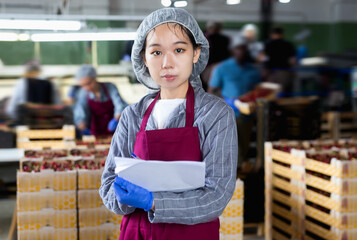 Asian female working with documents in cherry warehouse