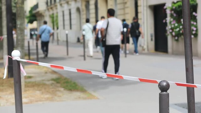 Red and white striped plastic tape in Paris, France. Boundary used to close off areas and streets. Parisian street closed for pedestrians.