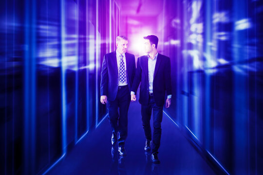 Younger and older man walking having a discussion with futuristic background
