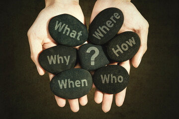 Closeup of unknown man holding pebbles of Five Ws questions