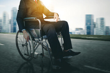 Close up of disabled businessman hand holding a wheel while using a wheelchair