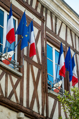 Driving in Champagne wine making region in Champagne, France. Streets, house decorated with french flags, summertime