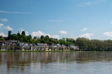 View.on old part of town of Gien on the Loire river, in Loiret department, France, houses with tiled roofs and chimneys, castle and bridge