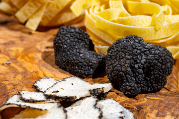 Cooking pasta with Italian black summer truffle, tasty aromatic mushroom, close up