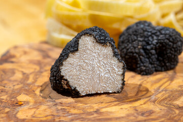 Cooking pasta with Italian black summer truffle, tasty aromatic mushroom, close up