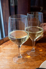Glass of txakoli or chacolí slightly sparkling very dry white wine produced in Spanish Basque Country in typical pinchos bar in old part of San Sebastian or Donostia, Spain