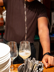 Pouring of txakoli or chacolí slightly sparkling very dry white wine produced in Spanish Basque Country in typical pinchos bar in old part of San Sebastian or Donostia, Spain