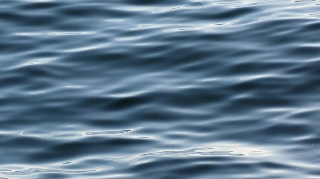 Continuously changing deep blue sea or ocean surface for a background. Beautiful, gently waving water on a summer afternoon. Meditative, abstract and minimalistic zen footage. Cinematic Baltic Sea.