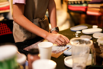 Grinding polymer plaster form with sandpaper during handmade workshop. Close up. 