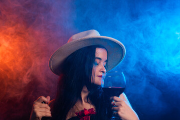 Beautiful woman wearing brown hat holding bottle and glass of wine.