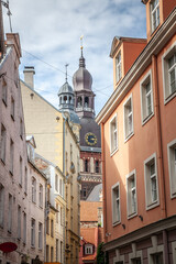 Historic Medieval Buildings in Vecriga, Old Riga, Latvia in Vecpilseta, the historical center old town of Latvian capital city with the Riga Dome Cathedral from a narrow street in Vecriga.