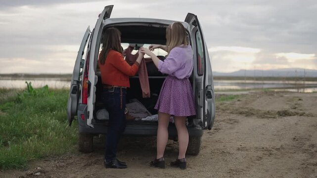 In a van two friends pick out clothes
