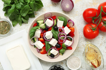 Bowl of healthy vegetable salad with ingredients on light grunge background