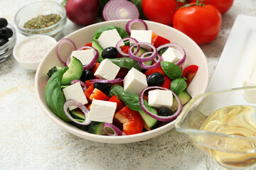Bowl of healthy vegetable salad with ingredients on light grunge background