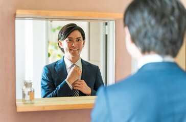 洗面所で身支度するスーツ姿の若い男性ビジネスマン
