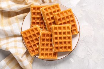 Plate with tasty Belgian waffles on grey background