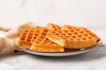 Plate with tasty Belgian waffles on grey table