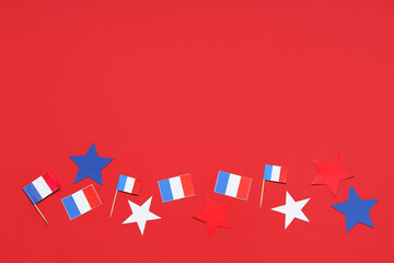 French flags and stars on red background. Bastille Day celebration