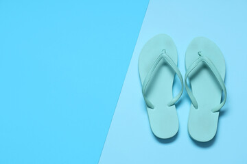 Stylish blue flip-flops on color background