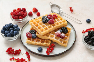 Plate of sweet Belgian waffles with different fresh berries on white background